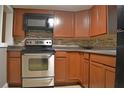Modern kitchen with wood cabinets, stainless steel appliances and granite countertops at 647 S Delaware Ave, Deland, FL 32720
