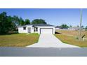 Single story home with white exterior, gray roof and attached garage at 3177 Sw 127Th St, Ocala, FL 34473