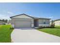 One-story home with gray siding, light-colored trim, and a two-car garage at 1717 Forest Run Ln, Auburndale, FL 33823