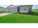 Front view of a one-story house with a neatly landscaped lawn at 1717 Forest Run Ln, Auburndale, FL 33823