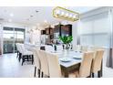 Elegant dining area with a large table and modern light fixture at 2220 Lelani Cir, Davenport, FL 33897