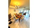 Open concept dining area with hardwood floors and chandelier at 7652 Whisper Way # 302, Reunion, FL 34747