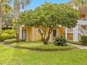Side view of a two-story yellow home with lush landscaping at 401 New Providence Promenade # 12401, Davenport, FL 33897