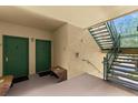 Condo building interior showing a stairwell and two green doors at 8810 Dunes Ct # 203, Kissimmee, FL 34747