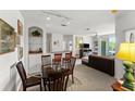 Living room with glass dining table, dark brown chairs, and a black couch at 8810 Dunes Ct # 203, Kissimmee, FL 34747