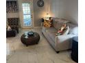 Bright living room with comfy sofa, coffee table, and tiled floors at 4301 Lizshire Ln # C-109, Orlando, FL 32822