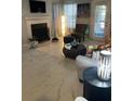 Living room features fireplace, large TV, and elegant tiled floors at 4301 Lizshire Ln # C-109, Orlando, FL 32822