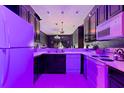 A kitchen with dark cabinets, white appliances, and purple lighting at 315 Lucaya Loop # 315, Davenport, FL 33897