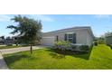 Newly built home with gray siding, two-car garage, and grassy yard at 273 Summershore Dr, Auburndale, FL 33823