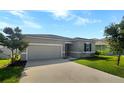 Two-car garage, gray exterior, and well-maintained lawn at 273 Summershore Dr, Auburndale, FL 33823