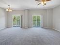 Spacious living room with carpeting and access to a balcony at 10888 Eclipse Lily Way # 62A, Orlando, FL 32832