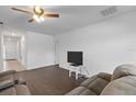 Living room with dark brown sectional sofa and wood-look flooring at 1100 James Way, Kissimmee, FL 34759
