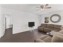 Spacious living room with dark brown sectional sofa and ceiling fan at 1100 James Way, Kissimmee, FL 34759