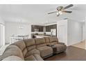 Open living room with sectional sofa, kitchen views, and wood floors at 1100 James Way, Kissimmee, FL 34759