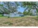 Spacious backyard with mature trees and a mobile home at 1825 Ruby St, Lakeland, FL 33815