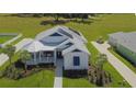 White house with blue accents, solar panels, and landscaped yard at 1077 Sugar Loaf Key Loop, Lady Lake, FL 32159