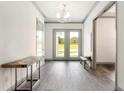 Bright entryway with wood-look flooring, bench, and natural light at 1077 Sugar Loaf Key Loop, Lady Lake, FL 32159