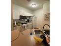 Well-equipped kitchen with white cabinets and modern appliances at 5518 Metrowest Blvd # 207, Orlando, FL 32811
