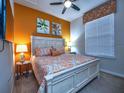 Spacious bedroom with an orange accent wall and king-size bed at 8887 Qin Loop, Kissimmee, FL 34747