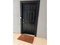 Black front door with brown doormat, located in a gray building at 5525 Pga Blvd # 4614, Orlando, FL 32839