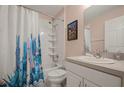 Clean bathroom with a shower/tub combo, cactus-themed shower curtain, and white vanity at 619 Kensington Dr, Davenport, FL 33897