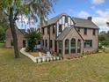 Two-story brick home with a sunroom and patio at 1689 Lakeshore Dr, Eustis, FL 32726