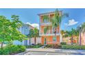 Two-story house with orange exterior, green accents, and palm trees at 8016 Flip Flop Way, Kissimmee, FL 34747