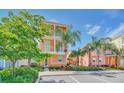 Two-story house with orange exterior, green accents, and palm trees at 8016 Flip Flop Way, Kissimmee, FL 34747