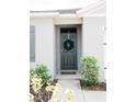 Inviting home exterior featuring a green front door and well-manicured landscaping at 909 Brooklet Dr, Davenport, FL 33837