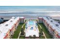 Aerial view of condo building, pool, and beach access at 3801 S Atlantic Ave # 321, New Smyrna Beach, FL 32169