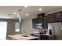 Modern kitchen with stainless steel appliances and an island at 8073 Cherrystone St, Leesburg, FL 34748