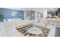 Open living room with white sectional sofa and kitchen view at 9076 Hazard St, Davenport, FL 33896