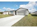 New gray house with light blue shutters and a two-car garage at 1748 Forest Run Ln, Auburndale, FL 33823