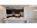 Modern kitchen featuring dark cabinetry, quartz countertops, and stainless steel appliances at 6804 Serpent Hawk Lane St, Howey In The Hills, FL 34737
