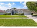 One story home with gray siding, two car garage and lush lawn at 12337 Greco Dr, Orlando, FL 32824