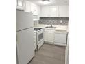 White kitchen with modern appliances and gray tile backsplash at 2557 N Alafaya Trl # 111, Orlando, FL 32826
