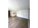 Open living area featuring gray laminate floors and access to kitchen at 2557 N Alafaya Trl # 111, Orlando, FL 32826