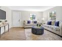 Bright living room featuring light beige couches and a patterned ottoman at 1500 N Clearview Ave, Deland, FL 32724