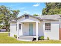 Charming bungalow with a light-grey exterior, teal door and grey steps at 1500 N Clearview Ave, Deland, FL 32724