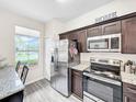 Kitchen with stainless steel appliances and dark cabinets at 744 La Mirage St, Davenport, FL 33897