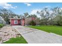 Brick house with red accents, a grassy lawn and driveway at 501 N Normandale Ave, Orlando, FL 32835