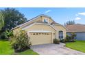 Inviting front yard with lush landscaping and a paved driveway leading to the attached garage at 33925 Terragona Dr, Sorrento, FL 32776