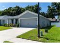 Gray house with a two-car garage and a well-maintained lawn at 3882 Willow Ridge Dr, Lakeland, FL 33810