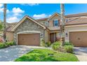 Two story home with stone accents and brown double doors garage at 10747 Belfry Cir, Orlando, FL 32832