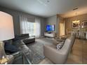 Spacious living room featuring a sectional sofa, armchairs, and large TV at 2937 Banana Palm Dr, Kissimmee, FL 34747