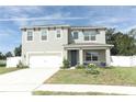 Two-story house with gray siding, white garage door, and landscaped front yard at 1186 August Sky Dr, Deltona, FL 32738