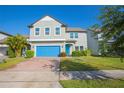 Two-story home with gray siding, blue garage door, and landscaped yard at 14166 Dove Hollow Dr, Orlando, FL 32824