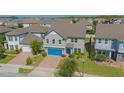 Aerial view of a two-story house with a blue garage door, located in a residential neighborhood at 14166 Dove Hollow Dr, Orlando, FL 32824