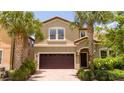 Two-story house with a brown garage door and palm trees at 8841 Rhodes St, Kissimmee, FL 34747
