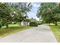 House exterior showcasing a large driveway and spacious green lawn at 24714 Martin St, Eustis, FL 32736